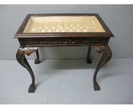 A MAHOGANY CURIO TABLE the rectangular hinged top with bevelled glazed panel and upholstered interior raised on cabriole legs