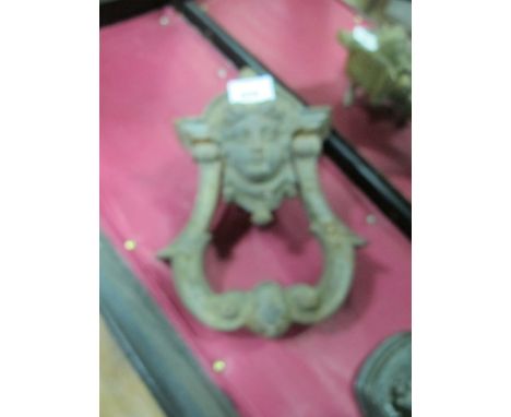 A CAST IRON DOOR KNOCKER 19th Century with figural mask cresting on scroll knocker