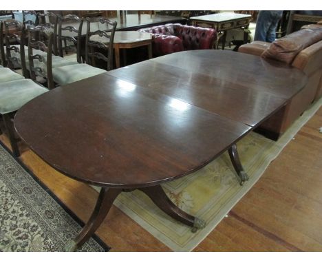 A GEORGIAN STYLE MAHOGANY D-END DINING TABLE the rectangular top with rounded ends and one loose leaf raised on twin tripod s