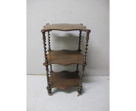 A VICTORIAN ROSEWOOD THREE TIER WHAT NOT the serpentine outline each moulded shelf joined by a spiral twist column on turned 