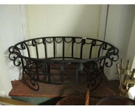 A WROUGHT IRON PLANTER of oval form with scroll decoration