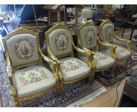 A SET OF FOUR CONTINENTAL GILTWOOD AND NEEDLEWORK UPHOLSTERED ELBOW CHAIRS each with a foliate and flowerhead cresting above 