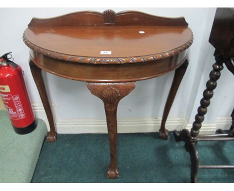 A CHIPPENDALE STYLE MAHOGANY BOW FRONT SIDE TABLE the shaped moulded top with gadrooned rim raised on cabriole legs with claw