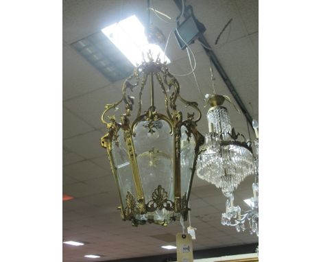 A GILT BRASS SINGLE LIGHT HALL LANTERN with glazed panels on scroll arms 88cm drop