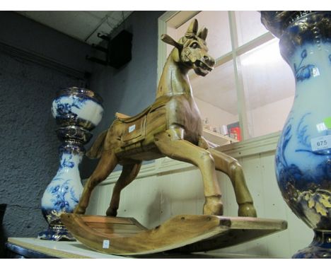 A CARVED WOOD ROCKING HORSE 88cm (h) x 34cm (w) x 93cm (d)