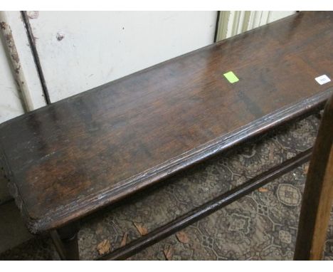 AN OAK STOOL 19th Century the rectangular moulded top raised on baluster supports joined by a cross stretcher on moulded legs