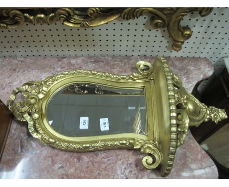 A CONTINENTAL GILT FRAME MIRROR the shaped bevelled glass plate within an egg and dart moulded frame ribbon tied cresting abo