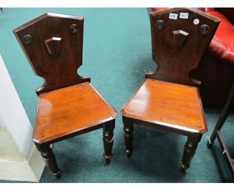 A PAIR OF EDWARDIAN MAHOGANY HALL CHAIRS each with a shield shaped back above a panel seat on octagonal ring turned legs