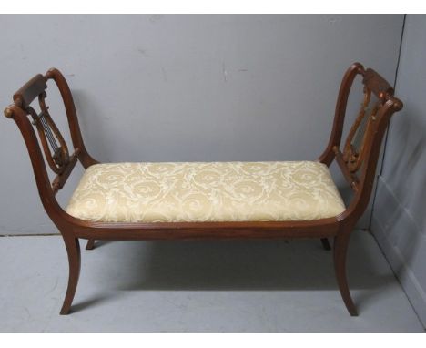 A REGENCY STYLE MAHOGANY DOUBLE LYRE END STOOL with upholstered seat on sabre legs 123cm wide