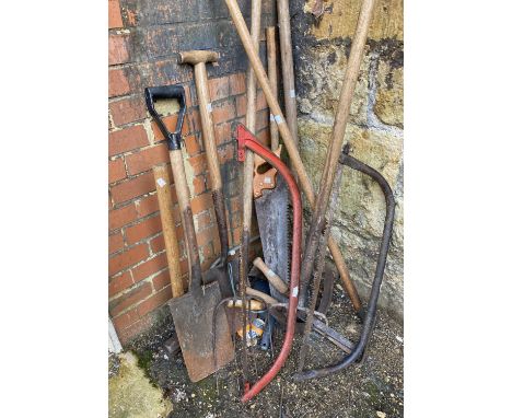 A quantity of garden tools to include spades, saws, sledgehammer etc 