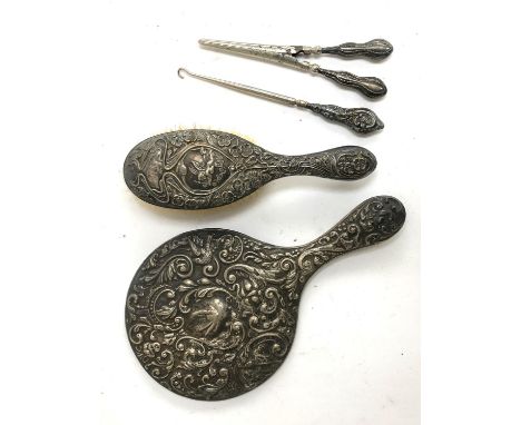A chased silver looking glass, together with a chased silver clothes brush, button hook, and tongs 