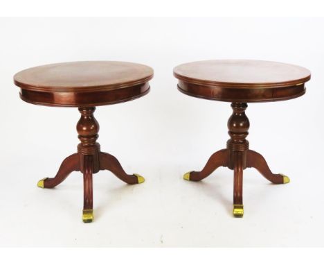 A pair of reproduction mahogany quarter veneered and crossbanded circular occasional tables, on ring turned columns and swept
