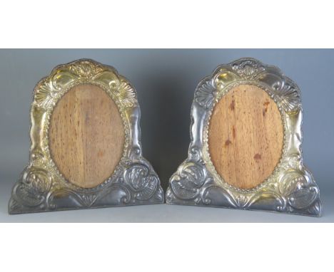 A pair of foreign silver easel photograph frames, stamped 925, of arched outline, with embossed scroll decoration, 32cm high,
