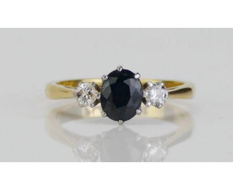 An 18ct Gold, Sapphire and Diamond Platinum Set Three Stone Ring, c. 6x5.1mm principal stone, 3mm brilliant round cuts, size 