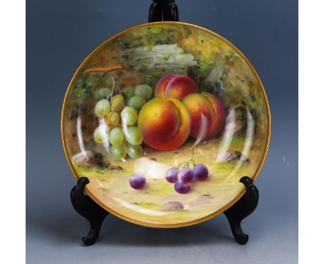 A Royal Worcester porcelain bowl decorated with a still life of peaches and grapes, signed A. Shuck, 21cm diameter. (chip to 