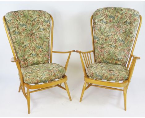 Two Ercol beech Evergreen lounge chairs, with padded cushion seat on turned legs linked by stretchers.