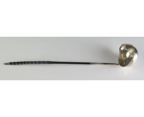 A George III silver punch ladle, marks worn, the oval bowl with inset coin mounted on a baline spiral twist handle, 35cm long