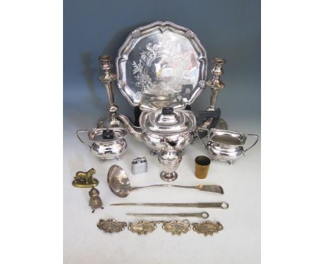 A collection of plated wares including tea service, candlesticks, soup ladle, wine labels, salver brass tiger, tot,