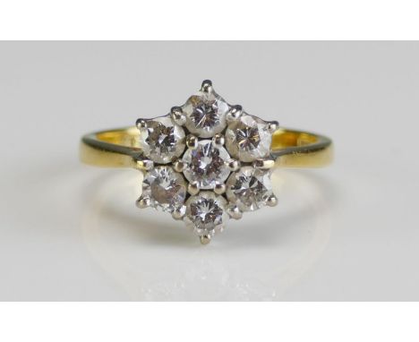 An 18ct Gold and Diamond Seven Stone Flower Head Cluster Ring, 11.9mm diam. head, size L, hallmarked, 3.9g