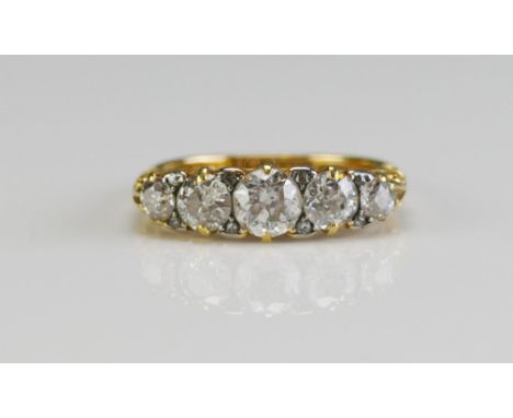 An 18ct Gold and Diamond Five Stone Ring, c. 5.4mm principal brilliant round cut with 4.6 and 3.5mm shouldering stones, size 