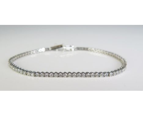 A 9ct white gold and diamond set line/tennis bracelet, with seventy seven diamonds, 190cm long.