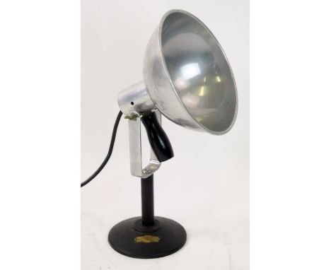 A vintage Sol-Tan angle-poise table lamp with circular aluminium shade, on a circular base.