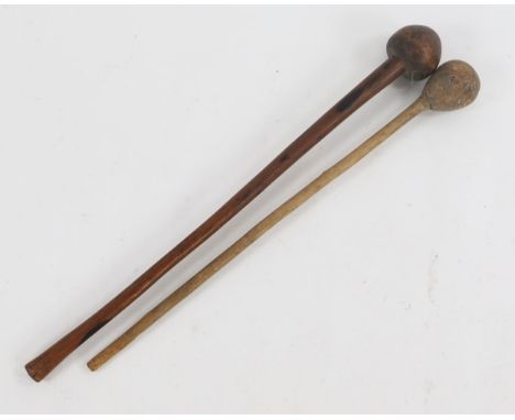 A tribal hardwood knobkerrie, with ball pommel of a slender tapering shaft, 70cm long, together with another club, 64cm long.