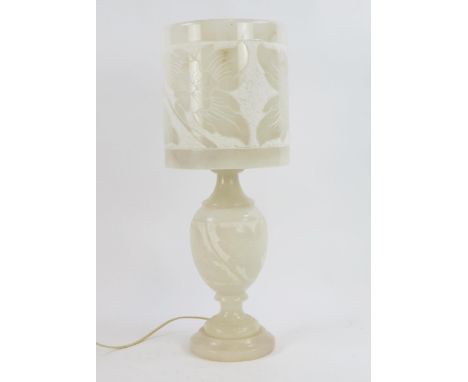An alabaster table lamp and shade, the base of ovoid form on a circular base, the shade with carved low relief floral decorat