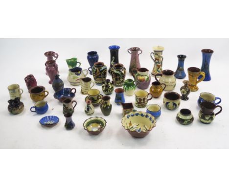 A collection of assorted Torquay and other pottery wares including mugs candlestick, vases, jugs etc