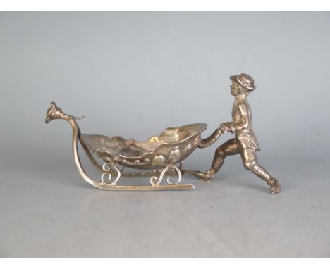 A continental silver table salt bears import marks for London, 1893, in the form of a man pushing a sledge, 11cm long, 69gms,