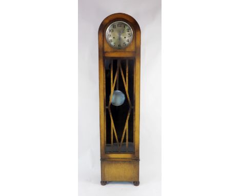 An Art Deco period dwarf longcase clock, the arched case with glazed panel door, having a 27cm silvered Arabic dial, the trip