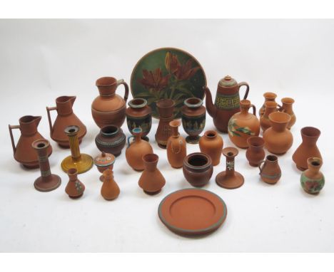 A collection of Torquay terracotta wars including dishes, candlesticks, jugs, pots, coffee pot etc.