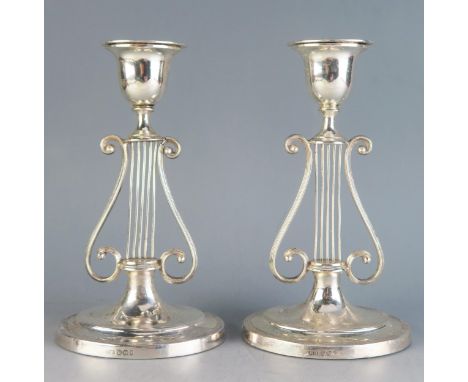 A pair of Victorian silver candlesticks, maker Harrison Brothers &amp; Howson, Sheffield, 1895, the urn-shaped sconces on lyr