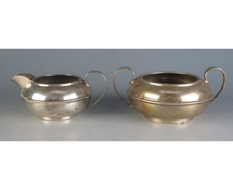 An Edward VII silver sugar basin and matching cream jug, maker Barker Brothers Silver Ltd, Birmingham, 1902, of plain circula