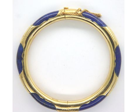 Yellow metal bound lapis lazuli snap bangle with guard chain, unmarked, D: 74 mm, 26g. P&amp;P Group 1 (£14+VAT for the first