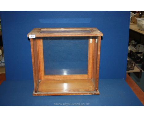 A four sided glass scientific scales Case on pale wood base. 17" tall.