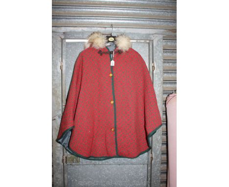 A pure new wool Cape in red and green tapestry having faux fur trim to hood.