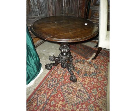 An Oak circular occasional Table having turned and lobed pillar with three elaborately carved scroll feet each depicting a di