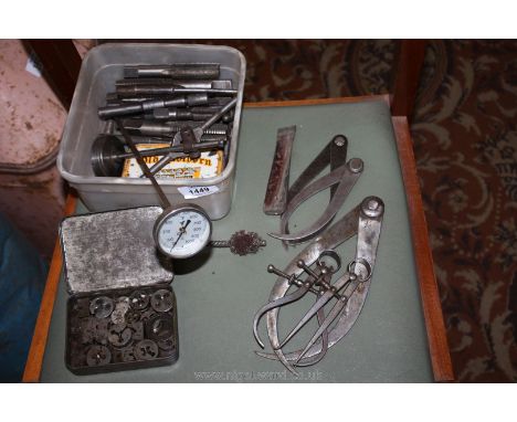 A quantity of large taps, two tobacco tins of taps and dies punches, dial gauge stand, five calipers and a probe thermometer 