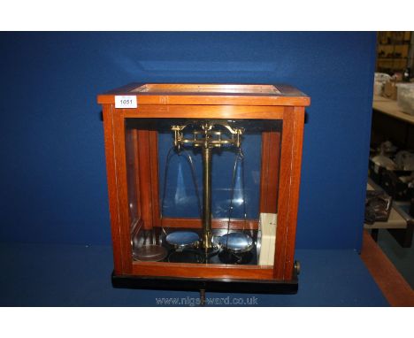 A set of brass laboratory Scales in display case.