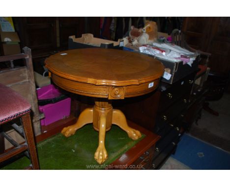 A mid Oak finished circular Occasional Table on a turned and reeded/lobed pillar with four legs terminating in ball and claw 