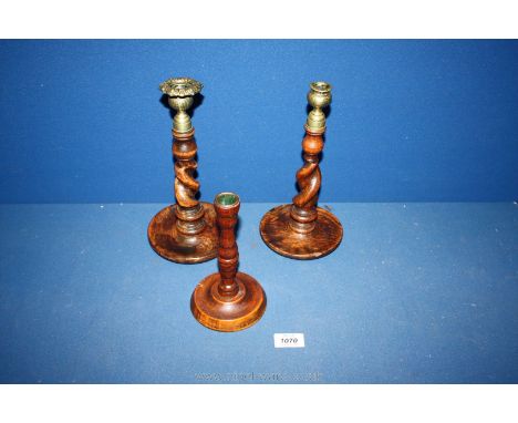 Two barley twist wooden Candlesticks with brass tops along with a smaller wooden candlestick.
