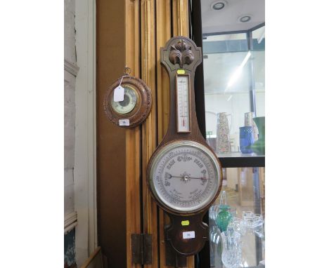 A carved walnut aneroid barometer, 18.5 cm diameter, and an oak framed banjo barometer 