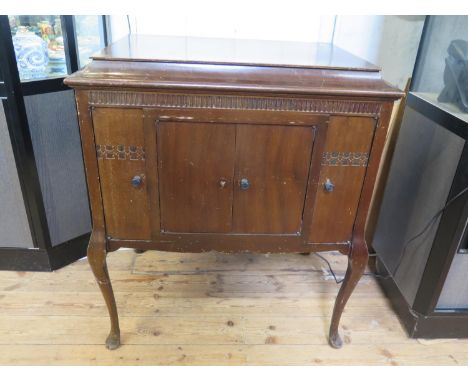 A mahogany cased Stylagram gramophone player, the hinged lid over a pair of speaker doors flanked by cupboard doors on cabrio
