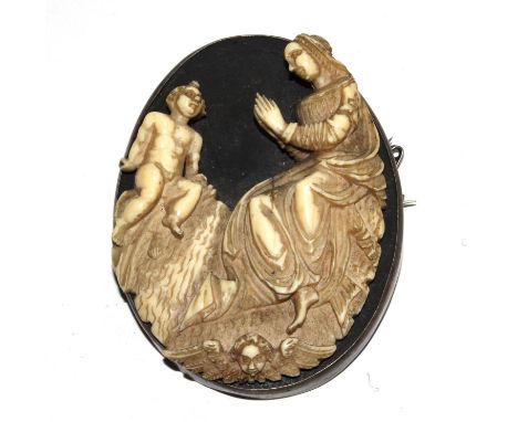 An early 19th century religious ivory carving, mounted as a brooch, 7 cm high 