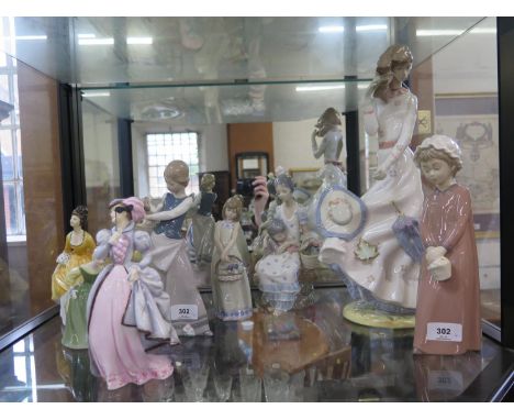 A Nao figure of a lady on a windy day with a parasol, 40 cm high, three Lladro female figures, another Nao figure (repaired),