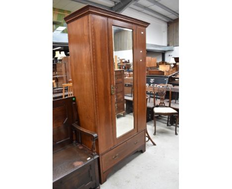 An Edwardian mahogany mirror door wardrobe having typical inlaid decoration