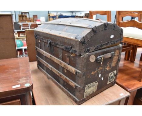 A large domed top travel trunk, bearing shipping labels including Union Castle line