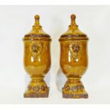 Pair of modern treacle glazed ceramic urn-shaped lidded vases with applied lion decoration (2)