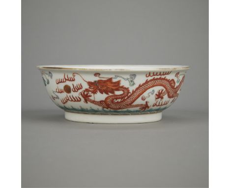 Chinese Qing porcelain bowl decorated along the sides with a phoenix flying towards a rising sun and a dragon chasing a flami